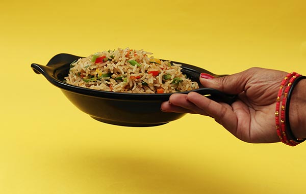 person holding black ceramic bowl with rice